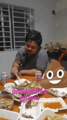 a man sits at a table with food and a can of coca cola on it