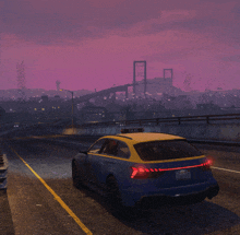 a blue and yellow taxi is driving down a highway at night
