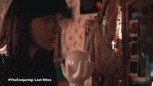 a woman looking at herself in a mirror with #theconjuring last rites written on the bottom