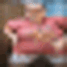 a blurry picture of a person wearing a pink shirt and a hat .