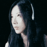 a woman with long dark hair wearing headphones on her head