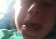 a close up of a person 's face with a green shirt on