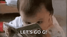 a baby is reading a book and saying let 's go g .