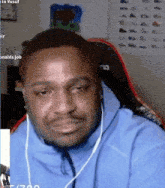 a man is sitting in a chair wearing headphones and making a funny face .