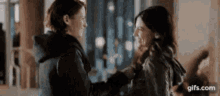 two women are standing next to each other and hugging each other .