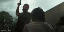 a man with a beard is pointing a gun at another man with the words pranay varma below him