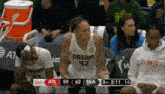 a basketball player wearing a dream 42 jersey sits on the bench