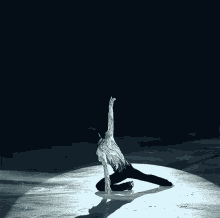 a figure skater is kneeling on the ice with his arms in the air