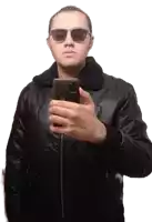 a man wearing sunglasses and a leather jacket takes a picture of himself