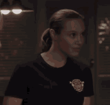 a woman is wearing a firefighter t-shirt and looking at the camera .