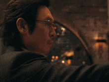 a man wearing glasses is holding a gun