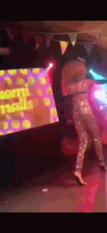 a woman is dancing on a stage in front of a screen that says worm nails