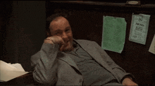 a man in a suit sits in front of menu papers
