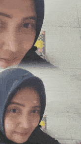 a woman wearing a hijab and a black shirt is smiling