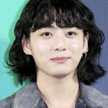 a close up of a woman 's face with short hair and a piercing in her ear .