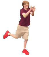 a man in a maroon shirt and tan shorts is standing on one leg