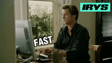 a man sitting in front of a computer with the word fast written on the screen