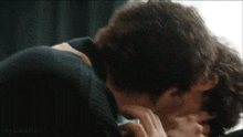 a man is kissing another man on the cheek .