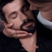 a man with a beard is being kissed by a woman with minimalmoons written on the bottom