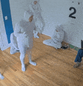 a man in a white bodysuit is dancing in front of a wall with the number 2 on it