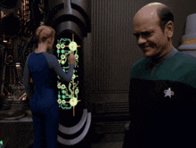 a man in a star trek uniform stands next to a woman in a blue jumpsuit