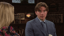 a man in a suit talks to a woman in a floral dress