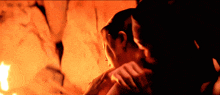 a couple kissing in front of a fire