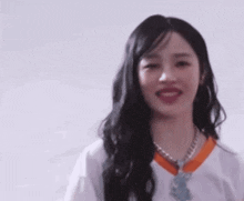 a close up of a woman with long black hair wearing a white shirt and tie .