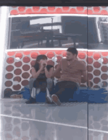 a man and a woman are sitting on a blue couch