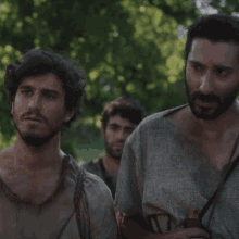 a man with a beard is standing next to another man with a beard
