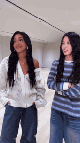 two women are standing next to each other in a room