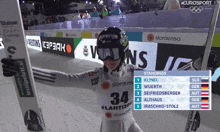 a person holding skis with the number 34 on their shirt