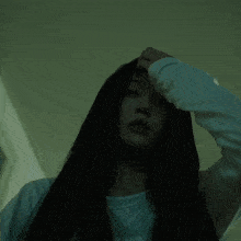 a woman with long black hair is looking up at the camera