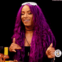 a woman with purple hair is smiling and wearing sunglasses