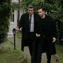 a man in a suit and tie is walking with another man