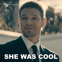 a man in a suit and tie with the words she was cool behind him
