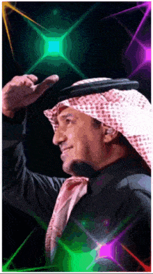 a man wearing a turban and a black shirt is surrounded by a rainbow of lights