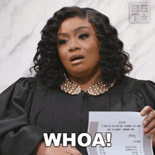 a woman in a judge 's gown is holding a piece of paper that says whoa