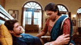 a man is laying in a hospital bed while a woman stands next to him .