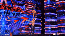 two men are doing a handstand on a stage in front of a sign that says americas talent
