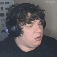 a man with curly hair wearing headphones with the hashtag matchu on the bottom right