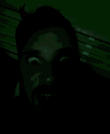 a close up of a person 's face in a dark room