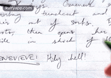 a person is writing on a piece of paper that says holy hell .