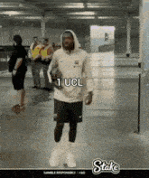 a man in a hoodie holding a soccer ball with the words 1 ucl written on it