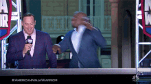 two men standing in front of a sign that says nbc