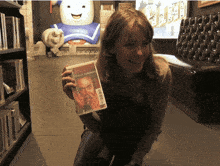 a woman kneeling down holding a dvd that says danger version on it