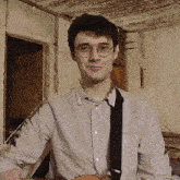 a young man wearing glasses and a white shirt is holding a guitar