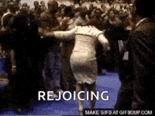 a woman in a dress is rejoicing in front of a crowd .
