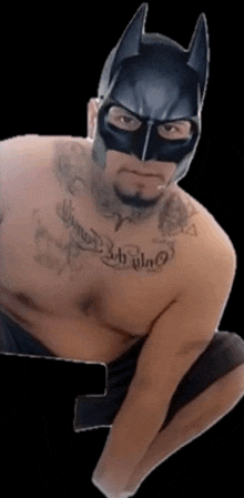 a man wearing a batman mask has a tattoo on his chest