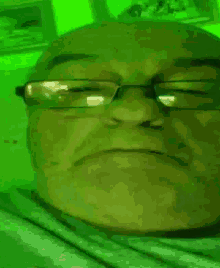 a close up of a man 's face with glasses